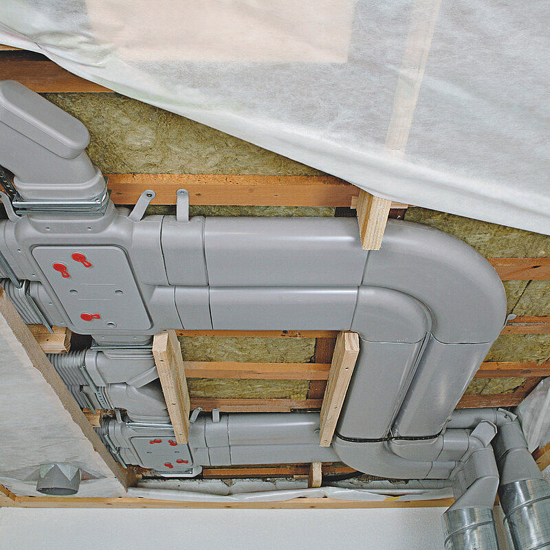 [Translate to Nederlands:] Installatie van het Comfoflat51 luchtverdeelsysteem met platte ventilatiebuis voor renovatie